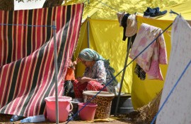 A woman sits outside her tent at a camp for locals displaced by a devastating earthquake in Amizmiz on September 16, 2023