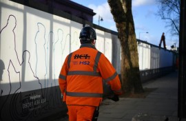 A construction worker walks outside a construction site for a section of Britain's HS2 high-speed railway project at London Euston train station 