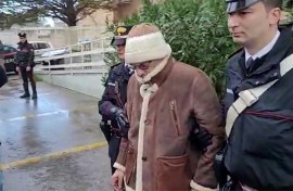 This handout video grab taken and released by the Italian Carabinieri Press Office on January 16, 2023 shows the transfer of mafia boss Matteo Messina Denaro (C) to an undisclosed location following his arrest