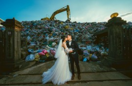 Iris Hsueh (L) and her fiance Ian Ciou take a wedding photo in front of a huge mound of garbage in Puli township, Taiwan