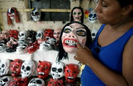 Artisan Fermina Lopez, standing in her workshop in an indigenous neighborhood in Masaya, Nicaragua, shows a devil's mask made for the annual Los Aguizotes festival  