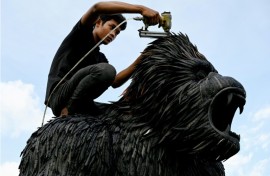 A worker fixes a King Kong statue made with old tyres at artist Mean Tithpheap's house in Cambodia