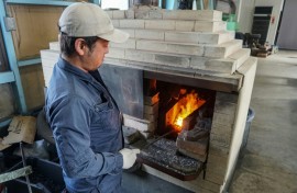 Yoshihiro Yauji, seen placing a piece of metal into a forge, believes 'blades are the foundational root of Japanese culture'