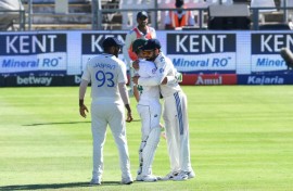 India's Virat Kohli (R) hugs South Africa's Dean Elgar (C) after the latter was out for 12 in his final Test innings