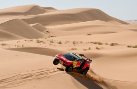 Heading for the rocks: Sebastien Loeb races through the dunes on stage 3 before suffering a series of punctures
