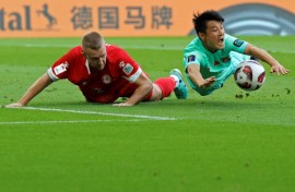 Lebanon  defender Robert Melki and China forward Wu Lei battle it out