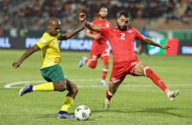 South Africa forward Percy Tau (L) crosses under pressure from Tunisia defender Ali Abdi
