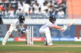 Ollie Pope lines up a reverse sweep as India's wicketkeeper Srikar Bharat watches 