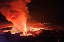 Live video images showed glowing lava oozing out of a fissure illuminating a plume of smoke rising up under the night sky