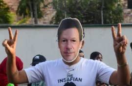 A man wearing a mask of jailed former Pakistan prime minister Imran Khan protests against alleged election rigging in Karachi 