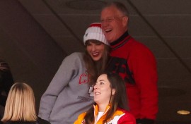 Scott Swift (top R), seen taking in an American football game with daughter Taylor Swift (L), is accused of punching a photographer