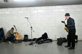 In an airy spot between two escalators a small group of musicians are unpacking their instruments, checking their music and calming any last minute nerves