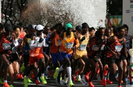 Men's elite runners including eventual winner Benson Kipruto (4th from right) and Eliud Kipchoge (white cap) set off at the start of the Tokyo marathon  