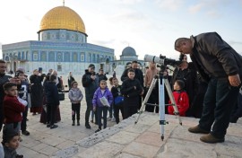 A man uses a telescope to look for the moon to mark the start of the Muslim holy month of Ramadan near the Dome of the Rock in Jerusalem