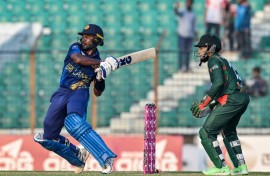 Sri Lanka's Janith Liyanage plays a shot as Bangladesh's Mushfiqur Rahim (R) watches during the first one-day international