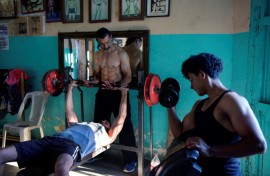 Walter Perez (C) helps a young man train in the gym he and his brother Arturo run in a town south of Managua