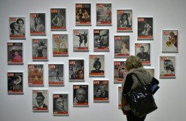 A woman looks at LIFE magazine copies as part of the show "Sorprendeme!", a retrospective of Philippe Halsman at CaixaForumin Madrid, November 30, 2016