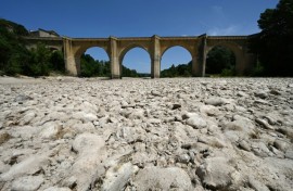 (FILES) A photograph shows the parched river bed of the Gardon near the Saint-Nicolas de Campagnac bridge in Saint-Anastasie, southern France, after a heat wave hit in June 2022