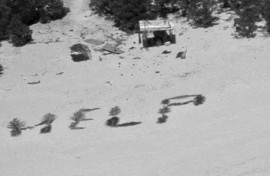The 'HELP' sign made with palm fronds by three mariners stranded on a remote island in Micronesia is seen in an image obtained from the US Coast Guard