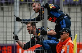 Red Bull team members celebrate on the pit wall as Max Verstappen wins