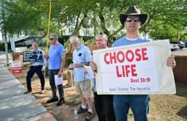 Matthew Engelthaler stands with a group of men from a local Catholic Church who gather "not to protest but to pray" for those arriving at Camelback Family Planning, an abortion clinic in Phoenix, Arizona 