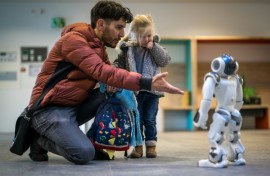 A father introduces his daughter to a robot called Nao in a Swiss creche  
