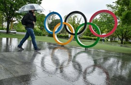 A visitor in the rain at the Japan Olympic Museum in Tokyo