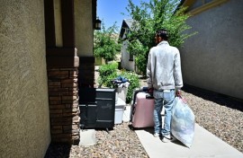 A man and his family gather their belongings after being evicted from a residential property