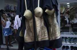 A woman looks at merchandise inspired by US pop star Madonna, including a conical corset top, at a shop in Rio de Janeiro