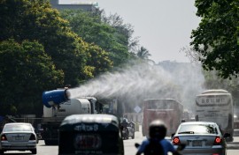 A vehicle of the Dhaka North City Corporation sprays water along a busy road to lower the temperature amidst a heatwave