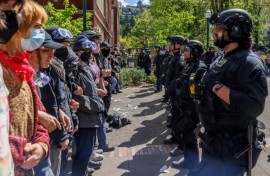 Pro-Palestinian students and activists face police officers after protesters were evicted from the library on campus earlier in the day at Portland State University in Portland, Oregon, on May 2, 2024