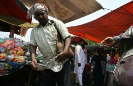 A volunteer distributes water during a hot summer day in Delhi on May 17