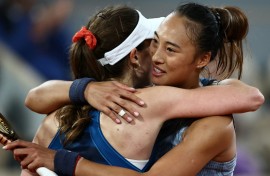 All over:  Zheng Qinwen embraces Alize Cornet after ending the Frenchwoman's career on Tuesday 