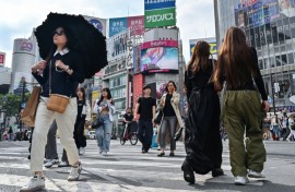 Pedestrians cross the intersection at Shibuya Crossing in Tokyo