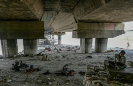 Homeless people are seen resting under a flyover to escape a searing heatwave in New Delhi on May 31