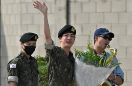 BTS superstar Jin (C) is greeted by bandmates RM (R) and Jimin after being discharged from his mandatory military service