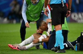Kylian Mbappe receives medical treatment after breaking his nose during France's 1-0 win against Austria at Euro 2024