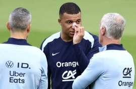 Kylian Mbappe, with a plaster on his broken nose, speaks to France coach Didier Deschamps at the team's Euro 2024 base in Paderborn on Wednesday
