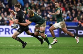 Springbok Pieter-Steph du Toit (C) tackles All Black Jordie Barrett during the 2023 Rugby World Cup final in Paris.