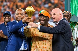 CAF president Patrice Motsepe (L), President Alassane Ouattara of the Ivory Coast and FIFA president Gianni Infantino hold the Africa Cup of Nations trophy after hosts Ivory Coast won the 2024 final.