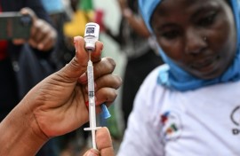A nurse prepares a dose of a vaccine against malaria on the first day of a vaccination drive in Ivory Coast
