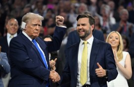 Republican vice presidential candidate J.D. Vance (R) shakes hands with Donald Trump during the second day of the 2024 Republican National Convention