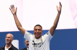 Kylian Mbappe salutes the Real Madrid fans as a former French hero at the club, Zinedine Zidane, looks on