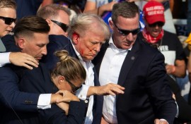 Secret Service agents shield former president Donald Trump as he is escorted off the stage following an attempted assassination