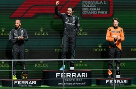 George Russell (C) celebrates his win in the Belgian Grand Prix where he finished ahead of Mercedes teammate Lewis Hamilton (L) and McLaren's Oscar Piastri (R)