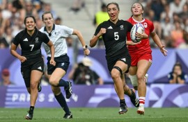 New Zealand's Sarah Hirini (2R) runs with the ball during the final victory over Canada