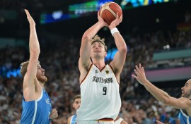 Germany's Franz Wagner takes a shot over Greece's Thomas Walkup and Nick Calathes in Germany's quarter-final win in the Olympic men's basketball tournament