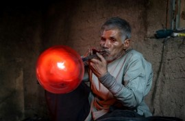 Afghan glassblower Ghulam Sakhi Saifi crafts glassware at his traditional workshop in the western city of Herat