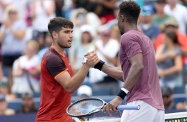 Spain's Carlos Alcaraz, left, shakes hands with Gael Monfils after falling to the Frenchman at the ATP and WTA Cincinnati Open