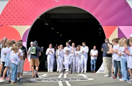 Former French wheelchair fencer Emmanuelle Assmann (C) emerges from the Channel Tunnel with the flame for the 2024 Paralympic Games 